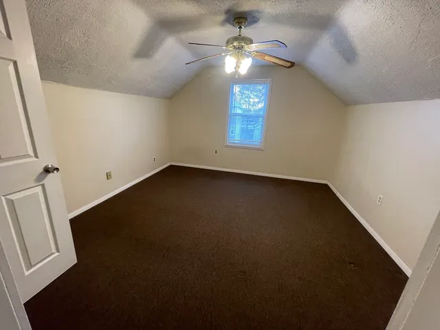 an empty room with closet and windows