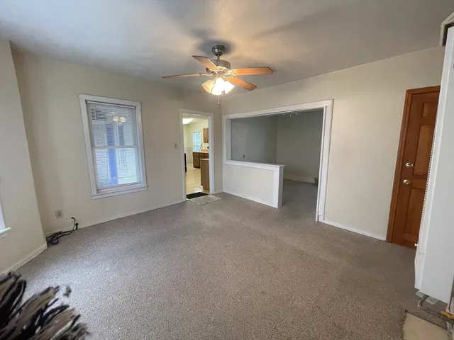 a view of a livingroom with a ceiling fan and window