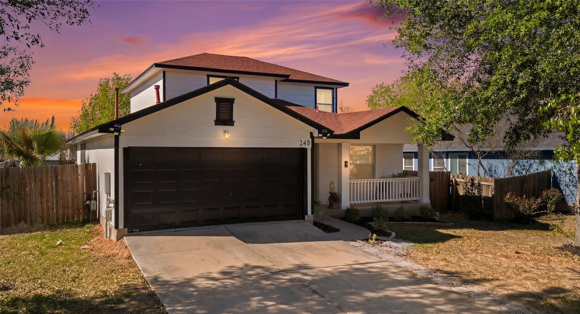 Traditional-style house featuring concrete driveway, a garage, and covered porch
