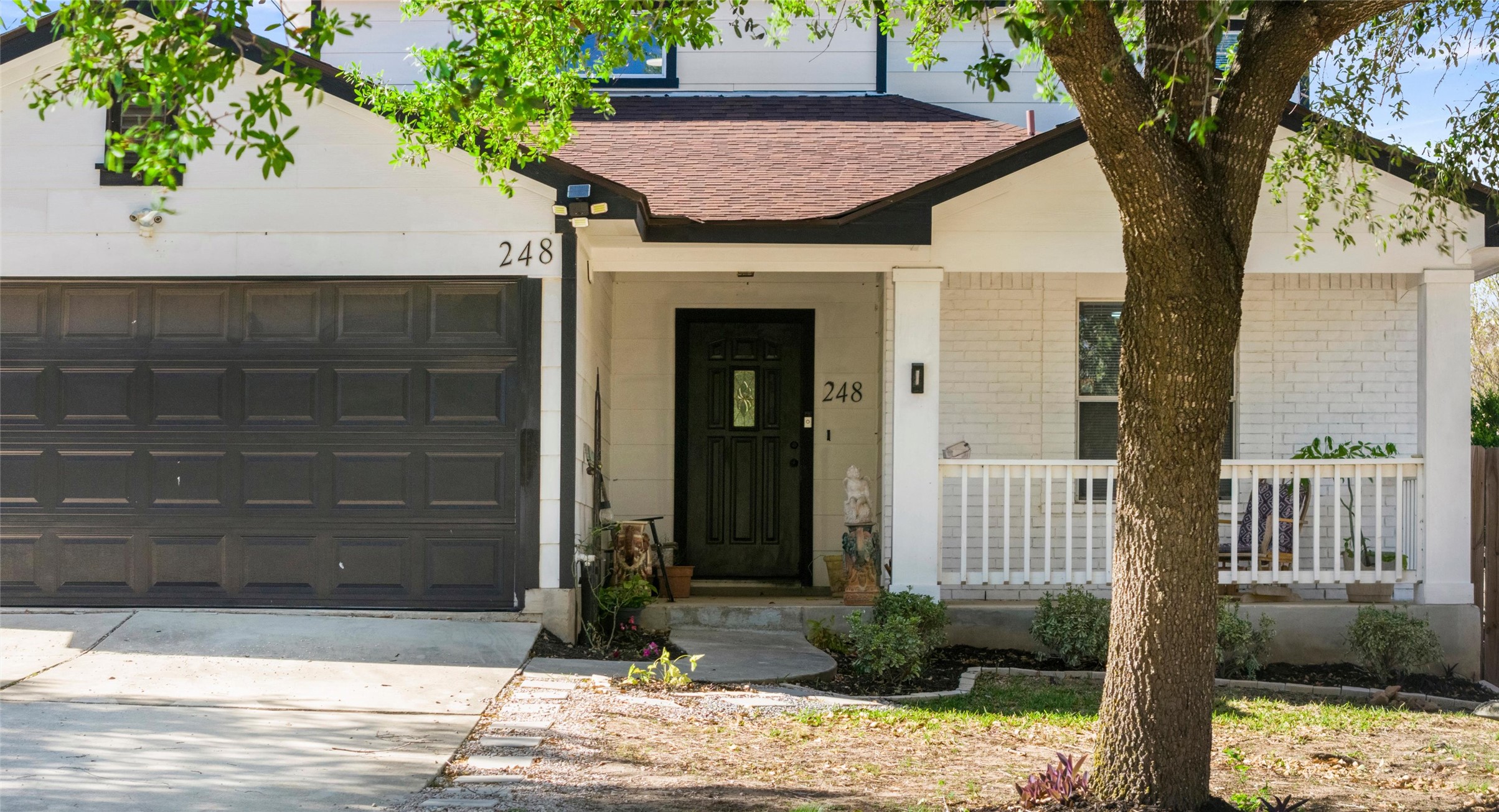 248 Endeavour Kyle, TX 78640 - Photo 2 of 32 View of front facade with brick siding, driveway, roof with shingles, a porch, and an attached garage