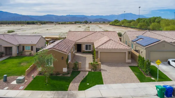 a front view of a house with a yard and mountain view