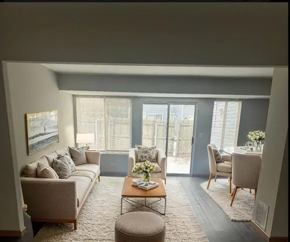 a living room with furniture and floor to ceiling windows