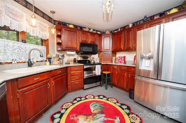 a kitchen with stainless steel appliances granite countertop a sink dishwasher a refrigerator and wooden cabinets