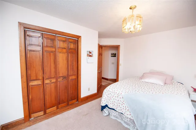 a large bed sitting in a bedroom next to a window