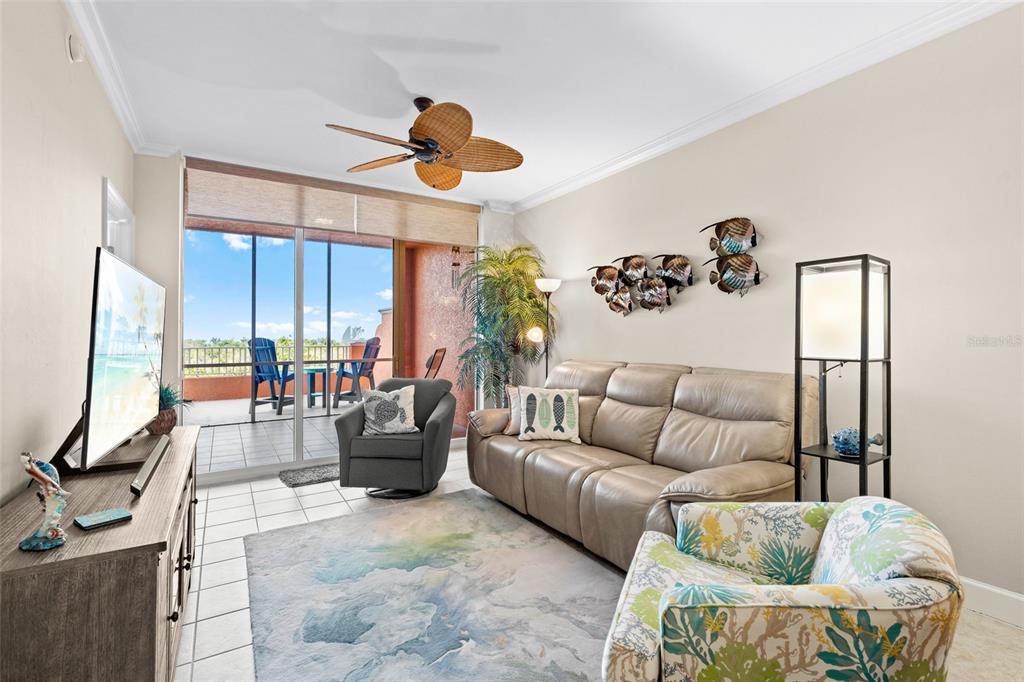 3191 Matecumbe Key Road, Unit 103 Punta Gorda, FL 33955 - Photo 11 of 48 a living room with furniture ceiling fan and a large window