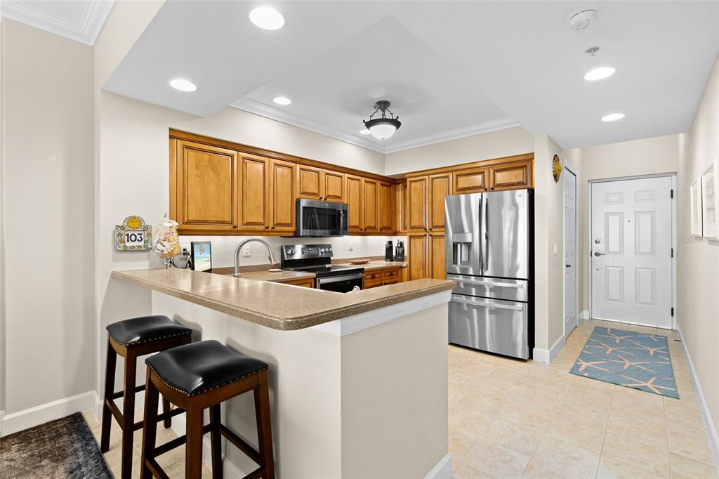 3191 Matecumbe Key Road, Unit 103 Punta Gorda, FL 33955 - Photo 6 of 48 a kitchen that has a sink a refrigerator a stove a dining table and chairs