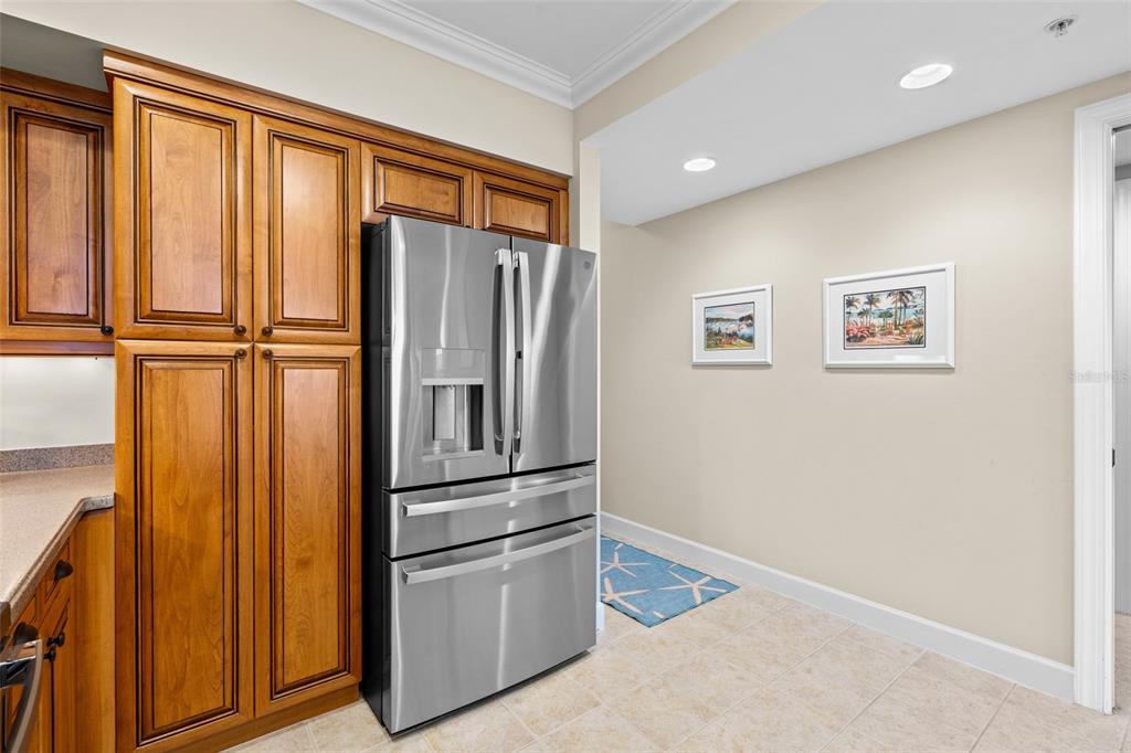 3191 Matecumbe Key Road, Unit 103 Punta Gorda, FL 33955 - Photo 7 of 48 a view of a refrigerator in kitchen and wooden floor