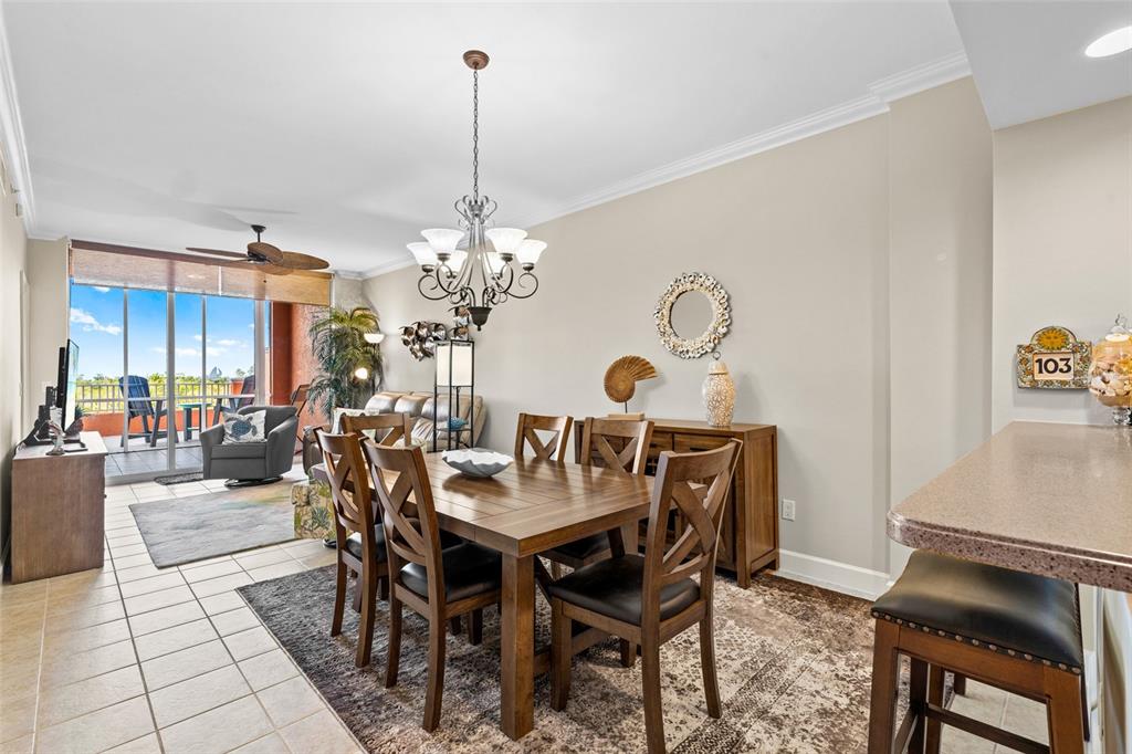 3191 Matecumbe Key Road, Unit 103 Punta Gorda, FL 33955 - Photo 9 of 48 a view of a dining room and livingroom with furniture wooden floor a rug a painting and a chandelier