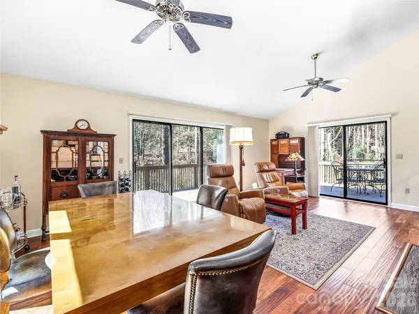 a living room with dining table a couch and a large window
