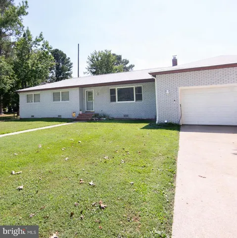 a view of a yard with a house and a large tree