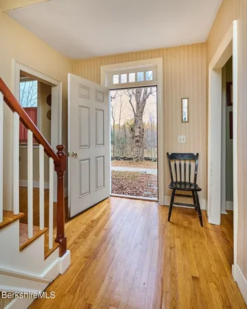 a view of an entryway with wooden floor and door