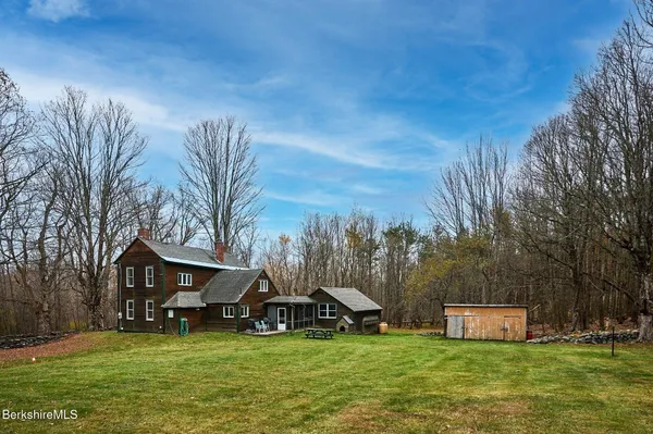 a view of a house with a big yard and a large tree