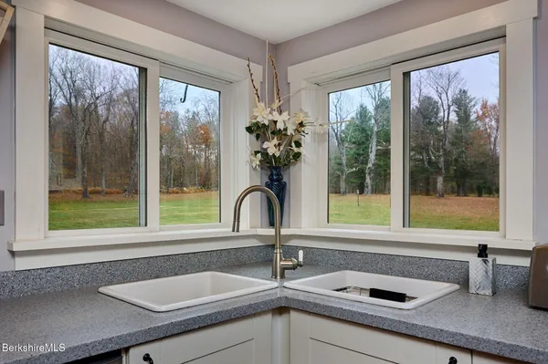 a sink with a large window and mirror