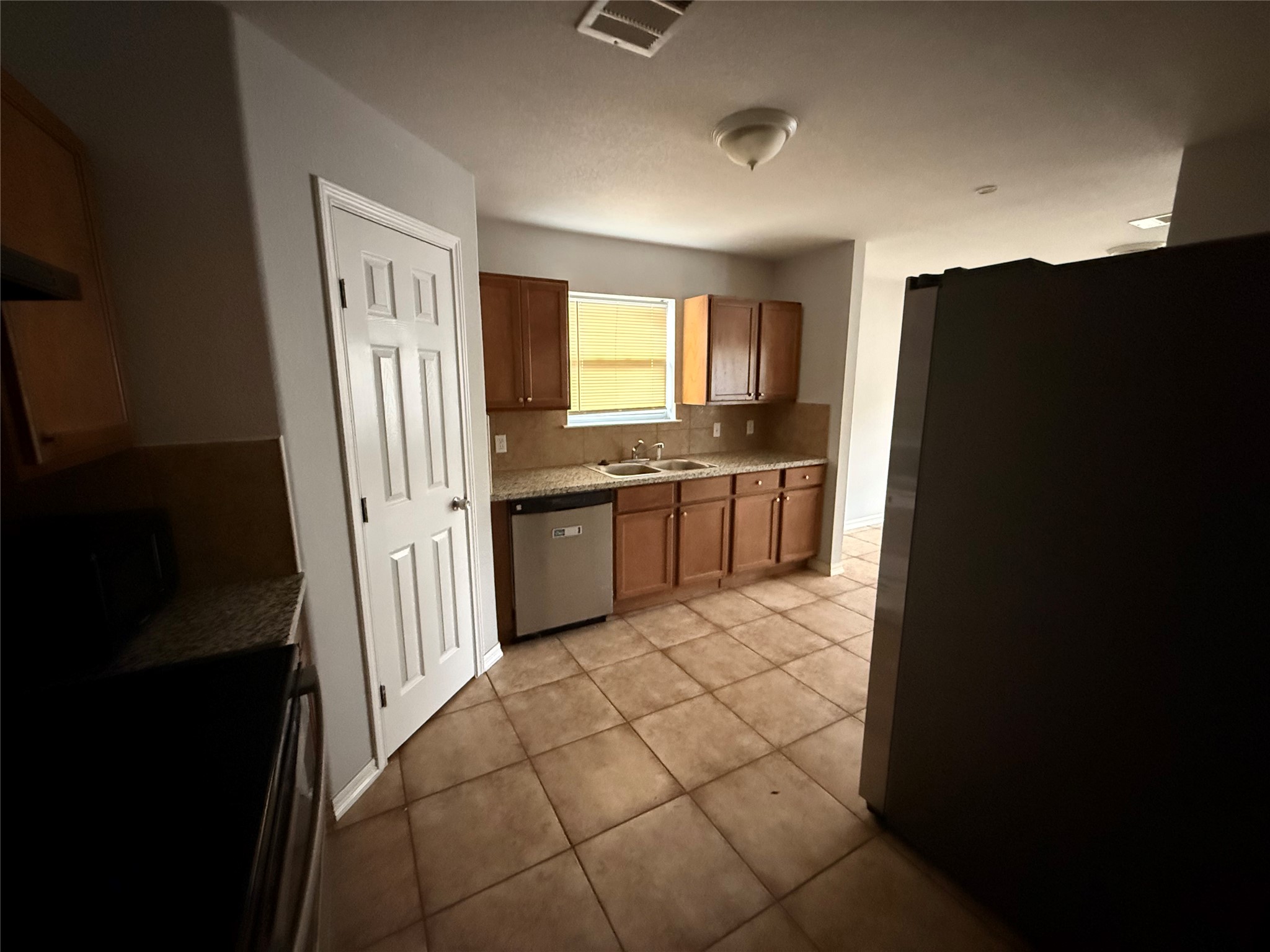 311 Kansas Street Bacliff, TX 77518 - Photo 11 of 12 a kitchen with stainless steel appliances granite countertop a refrigerator and a sink