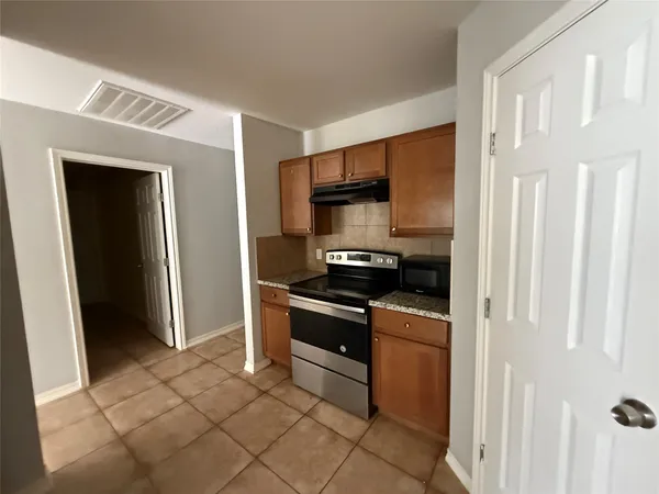 a kitchen with stainless steel appliances granite countertop a refrigerator and a stove