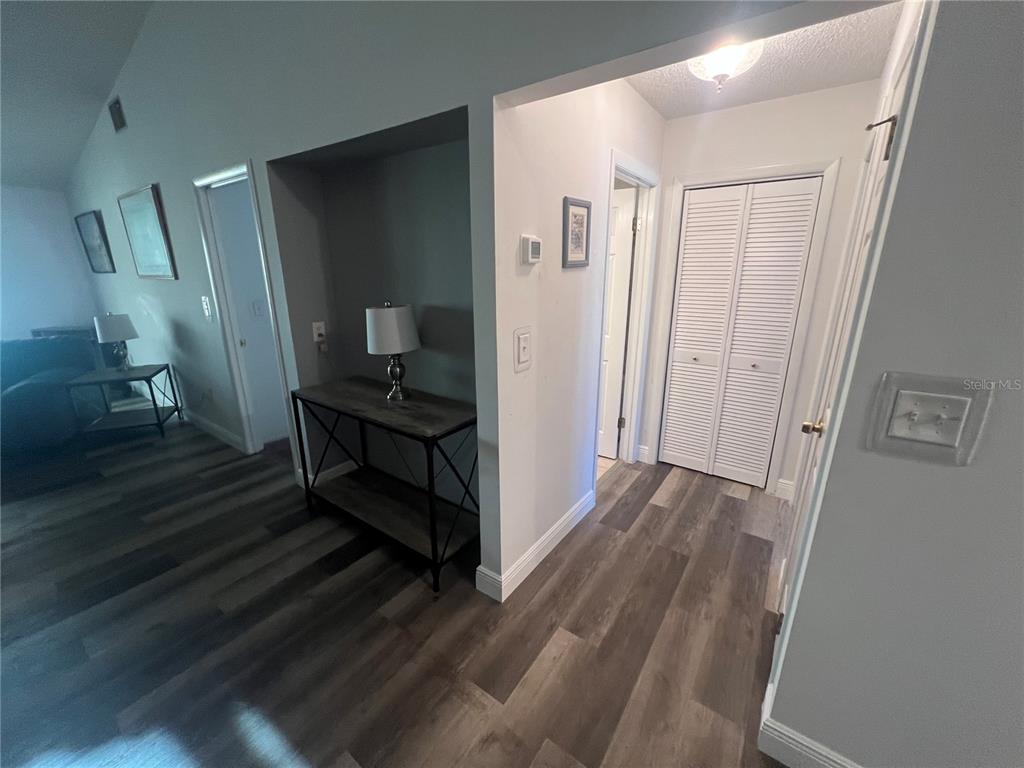 9980 Eagles Point Circle, Unit 3 Port Richey, FL 34668 - Photo 14 of 23 a view of a hallway with wooden floor and a bathroom