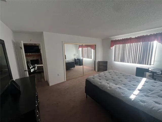 a spacious bedroom with a bed and a dresser in it