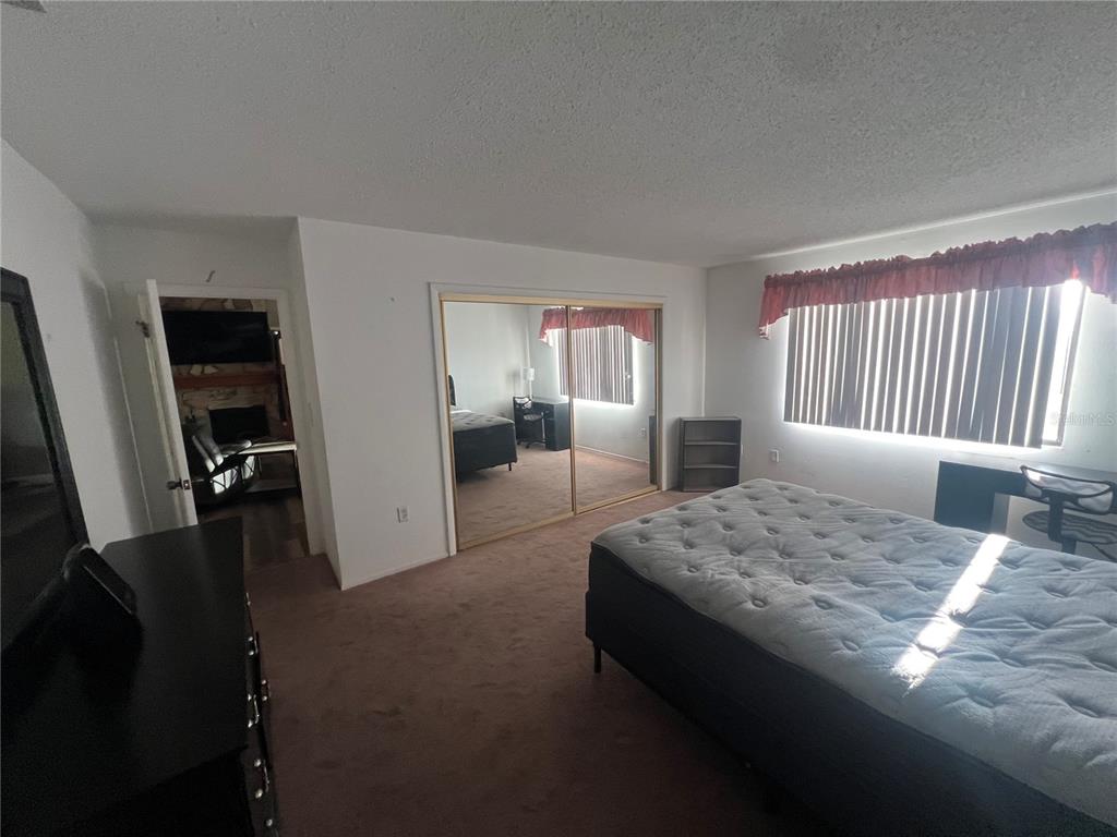 9980 Eagles Point Circle, Unit 3 Port Richey, FL 34668 - Photo 15 of 23 a spacious bedroom with a bed and a dresser in it