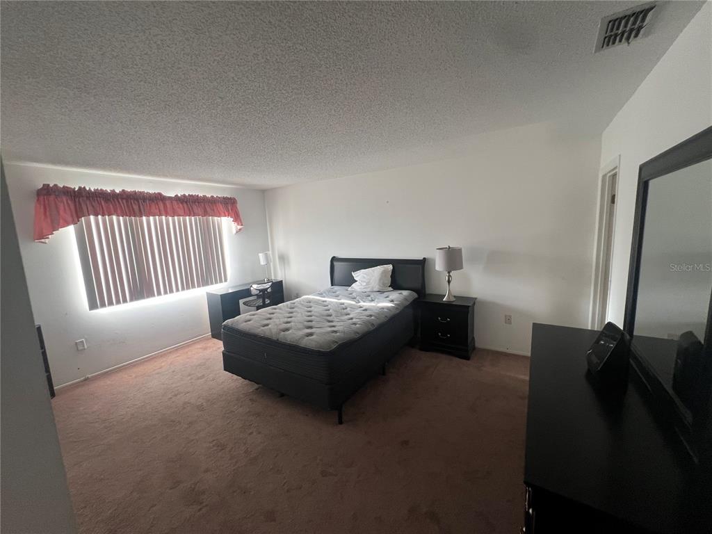 9980 Eagles Point Circle, Unit 3 Port Richey, FL 34668 - Photo 18 of 23 a bedroom with a bed and a mirror