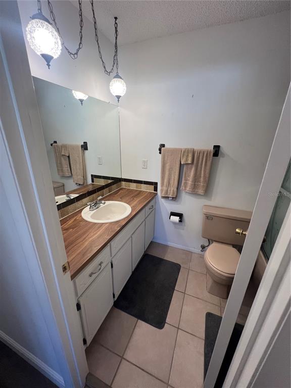 9980 Eagles Point Circle, Unit 3 Port Richey, FL 34668 - Photo 20 of 23 a bathroom with a granite countertop sink a toilet a mirror and vanity
