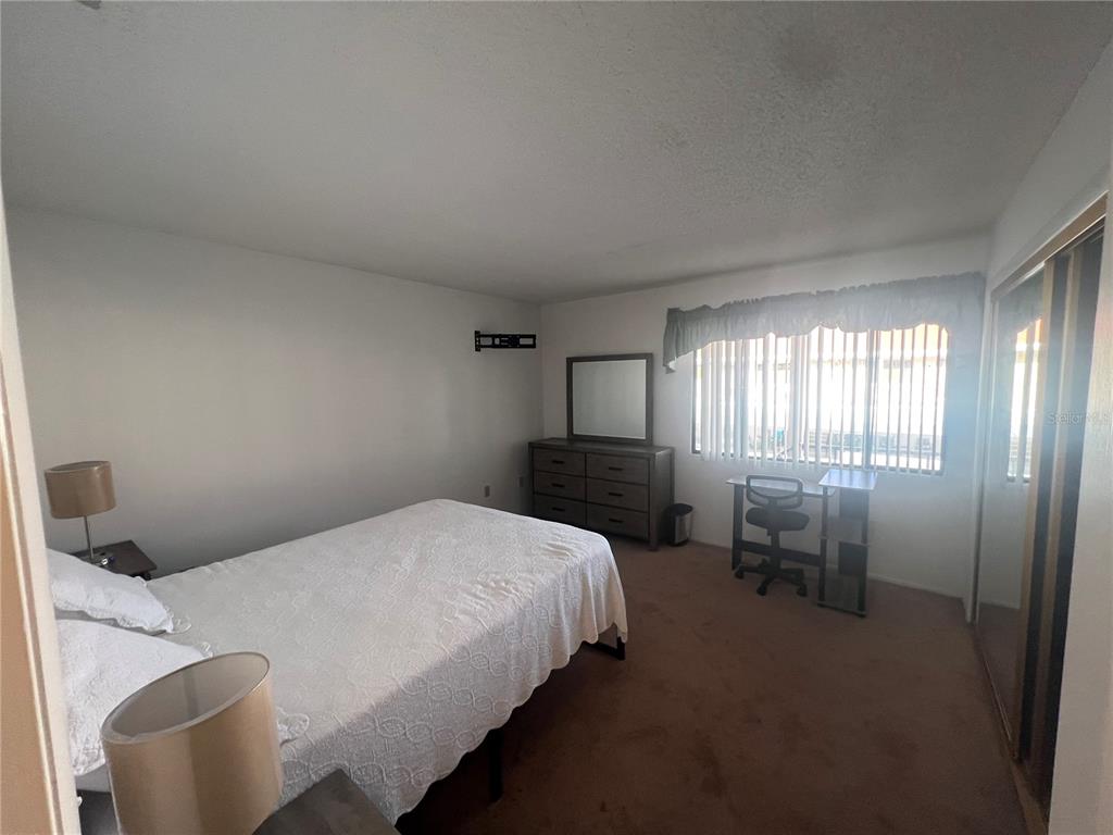 9980 Eagles Point Circle, Unit 3 Port Richey, FL 34668 - Photo 21 of 23 a bedroom with a bed and a window