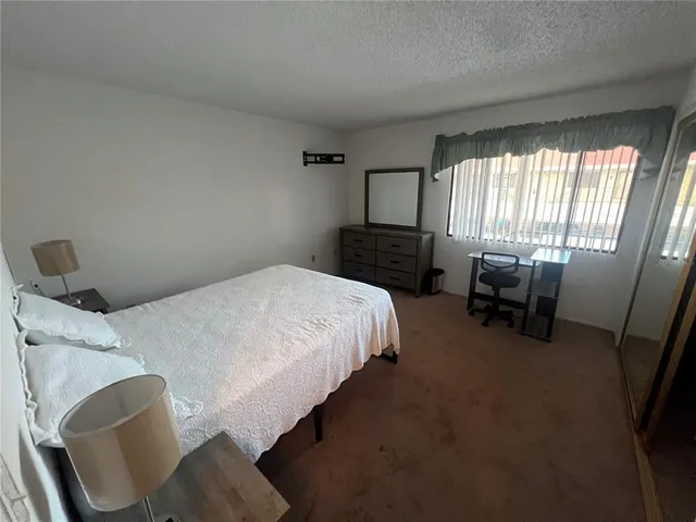 a bedroom with a bed chair and window