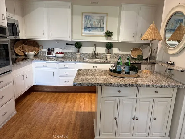 a kitchen with granite countertop white cabinets and a sink