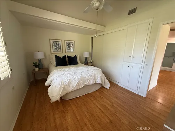 a bedroom with a bed and wooden floor