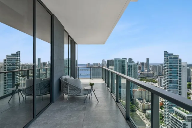 a view of a city from a balcony with furniture
