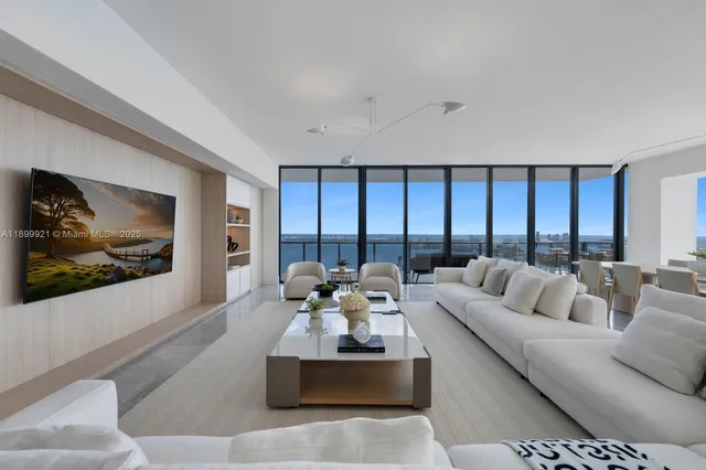 a living room with furniture and large windows