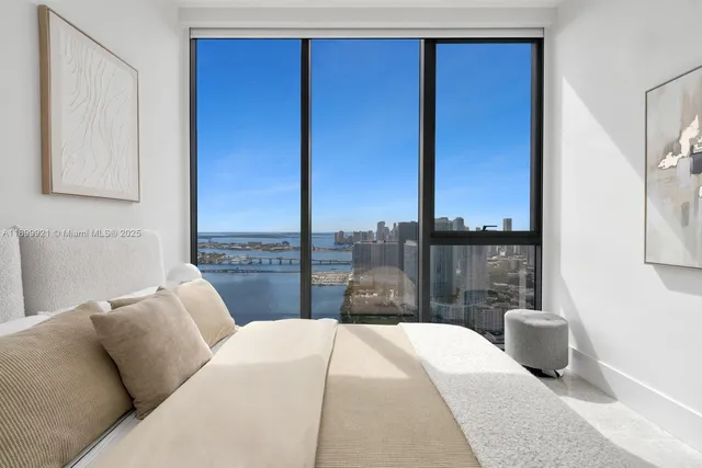 a bedroom with a large bed and a potted plant