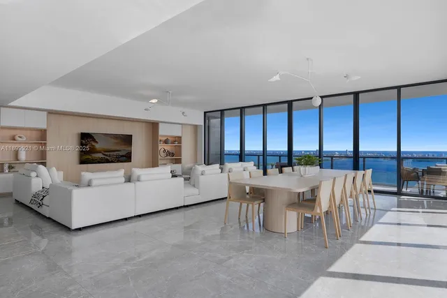a living room with fireplace furniture and a large window
