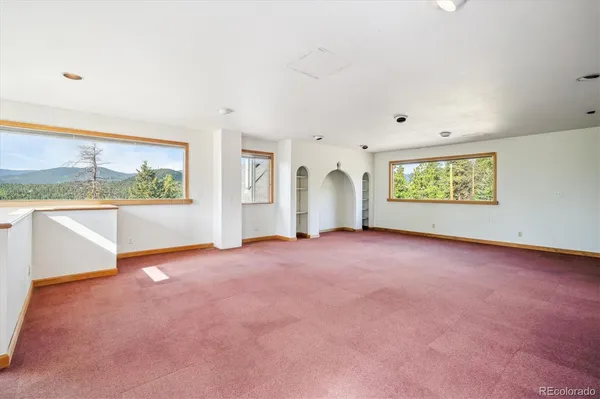 an empty room with windows and closet