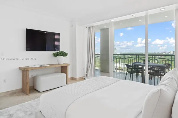 a bedroom with a large bed and a large window