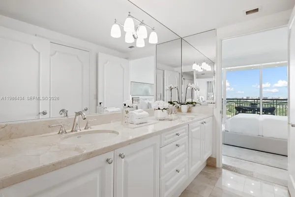 a bathroom with double vanity and a mirror