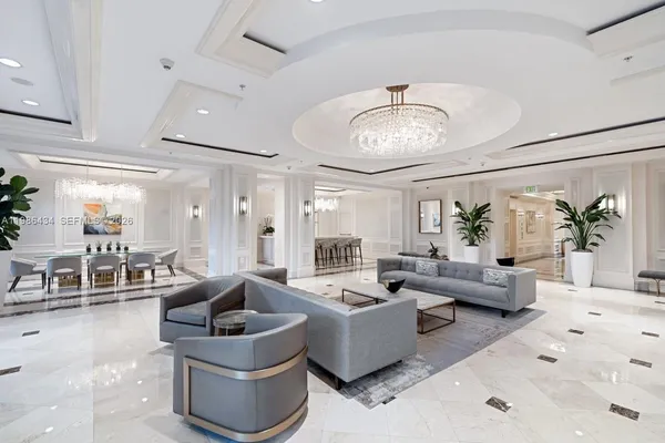 a living room with furniture potted plant and a chandelier