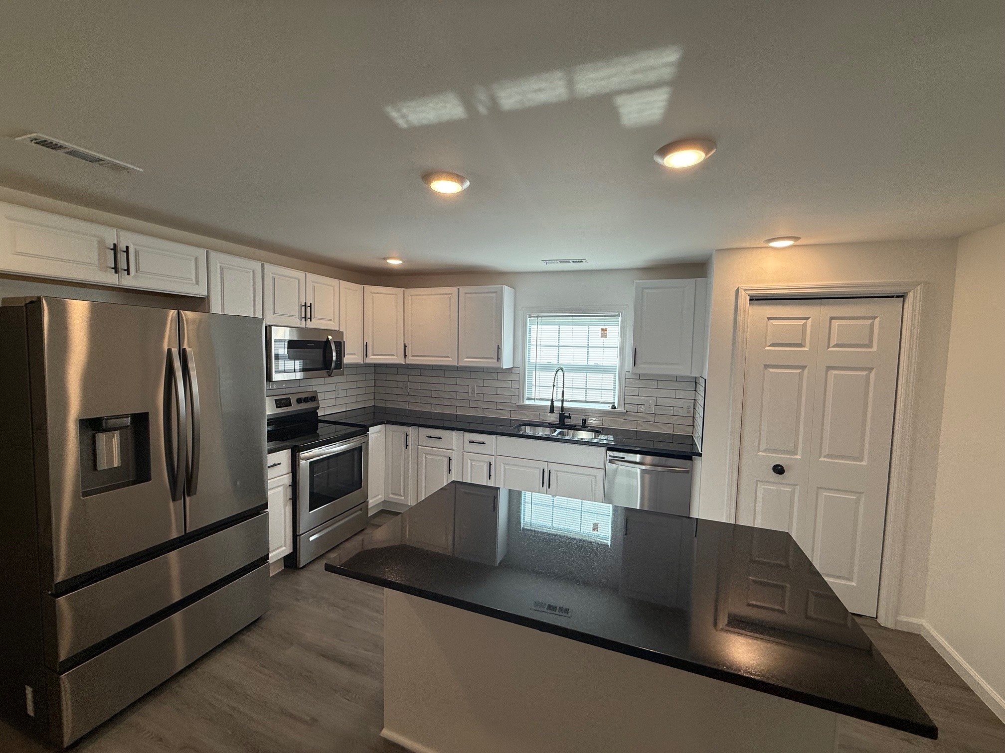 140 Phillips Street Pulaski, TN 38478 - Photo 7 of 32 a kitchen with granite countertop a refrigerator a sink a stove a dining table and chairs