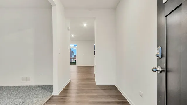 a view of a hallway with wooden floor