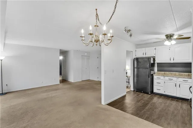 a view of a kitchen with refrigerator and a stove top oven