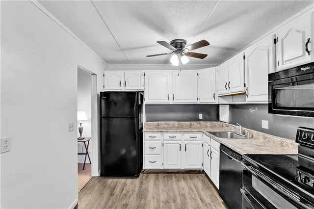 a kitchen with a refrigerator a sink and dishwasher with wooden floor