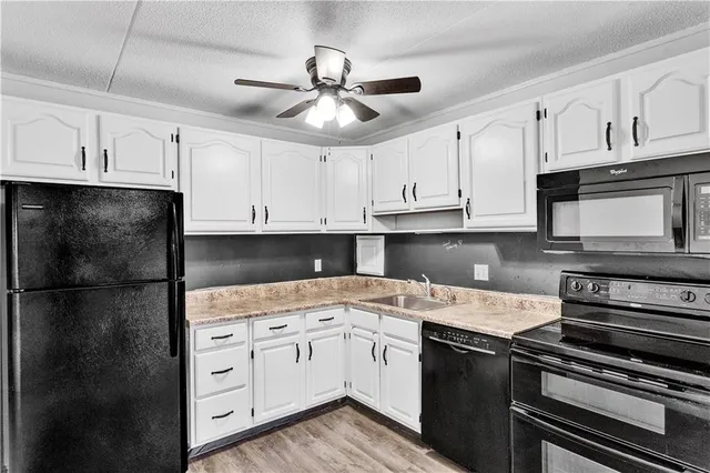a kitchen with a sink stove and white cabinets