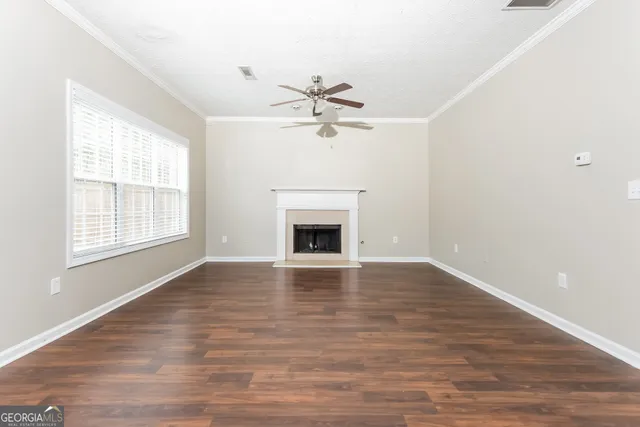 a view of an empty room with a window and fireplace