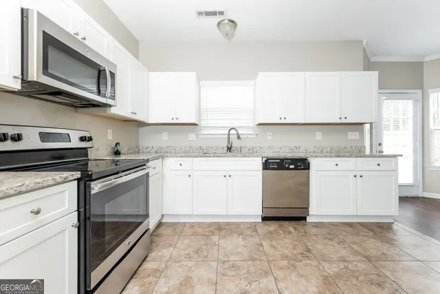 a kitchen with stainless steel appliances granite countertop a stove microwave and cabinets