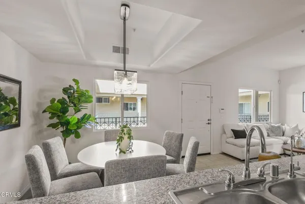 a kitchen with stainless steel appliances granite countertop a stove a sink and a refrigerator with wooden cabinets