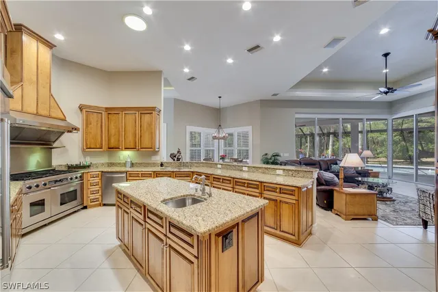a kitchen with stainless steel appliances granite countertop a sink and a refrigerator