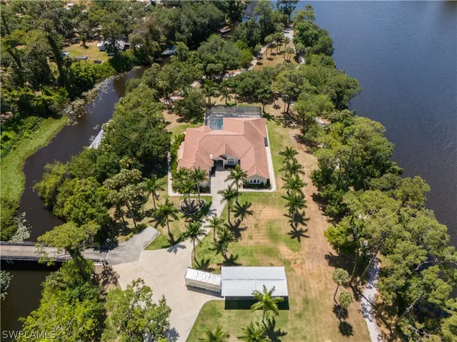 an aerial view of residential houses with outdoor space and trees