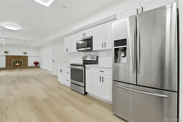 a kitchen with stainless steel appliances a refrigerator sink and microwave