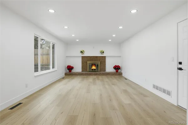 a view of an empty room with a window and a fireplace