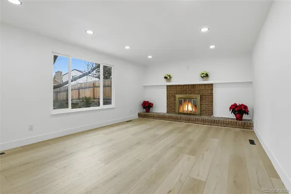 a view of an empty room with a fireplace and a window