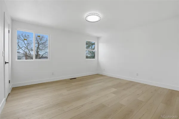 an empty room with a painting on the wall and a window